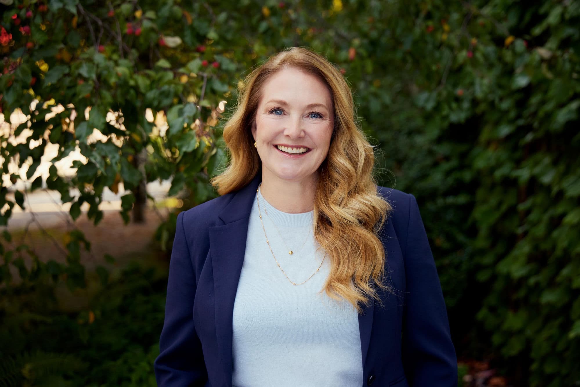 Joyce Gillespie standing outdoors in Vancouver, wearing a navy blazer, smiling at the camera